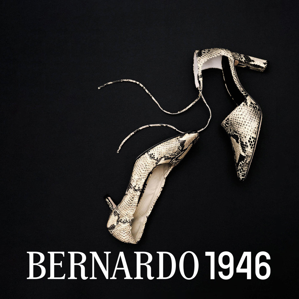 Pair of snake skin high heels on a black background with 'Bernardo 1946' branding.