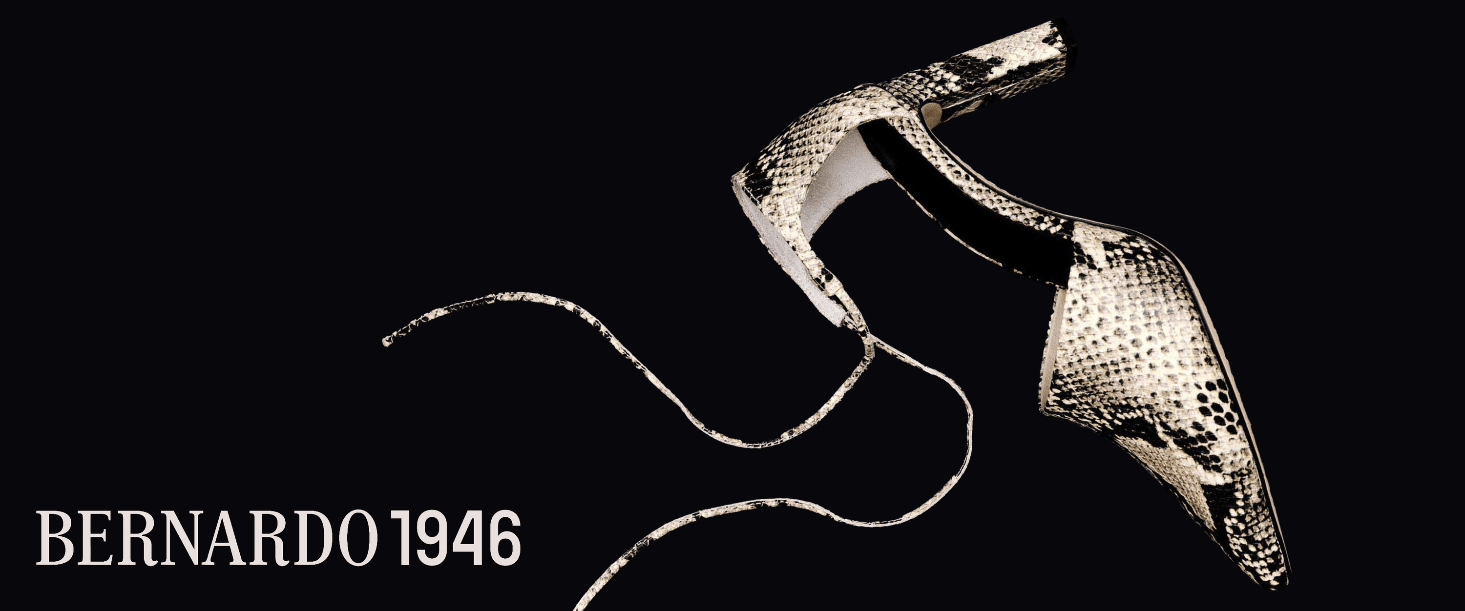 gold high-heeled Bernardo 1946 shoes with snake skin pattern on a black background