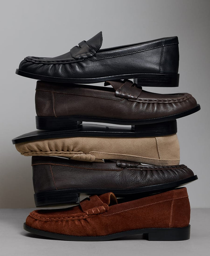 Stack of Bernardo women’s penny loafers in black leather, brown leather, sand suede and rust suede