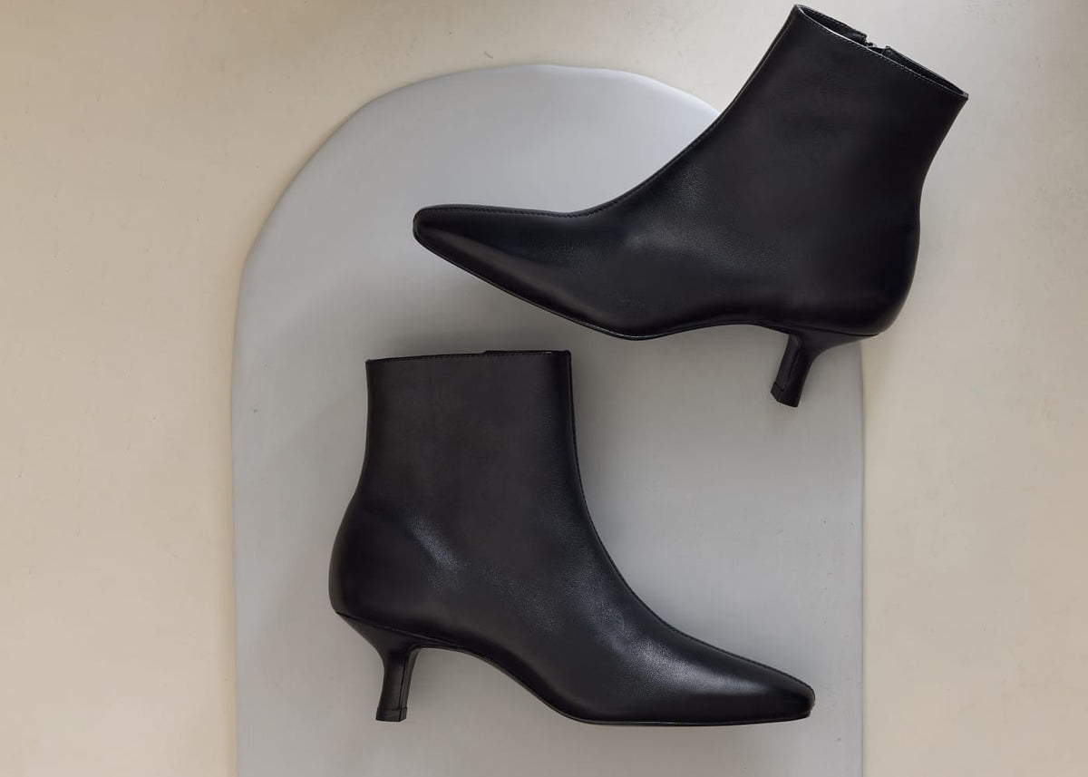 Bernardo black leather ankle boots with kitten heels and a pointed toe.